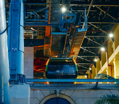 the cabin leaves the cable car parking lot, climbing up the cables. The technical elements are visible: supports, tensioned cables, lift mechanisms and electrical panels, as well as cable equipment