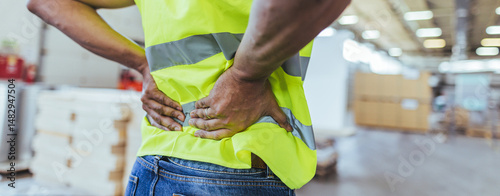 Konstfotografi Worker Experiencing Back Pain in a Warehouse Environment While on Duty