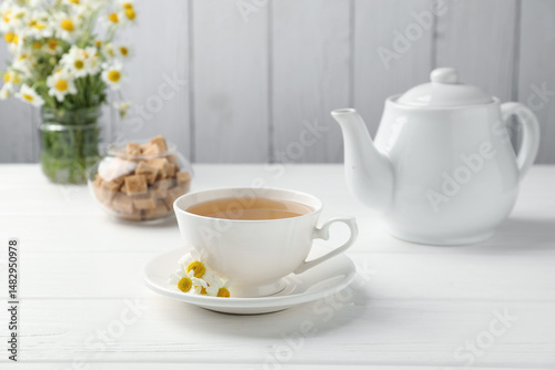 Wallpaper Mural Delicious chamomile tea in cup, fresh flowers and brown sugar on white wooden table Torontodigital.ca