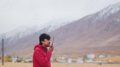 Wallpaper Mural Portrait of an Indian man talking on a walkie talkie in front of snowy Himalayan mountain peaks at Padum in Zanskar Valley, Ladakh, India. Man talks on wireless radio during the bad weather. Torontodigital.ca