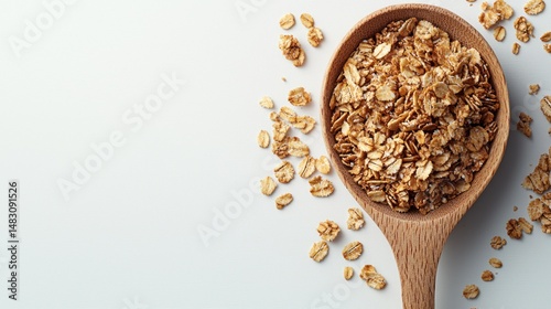 Rolled oats in wooden spoon on white. photo