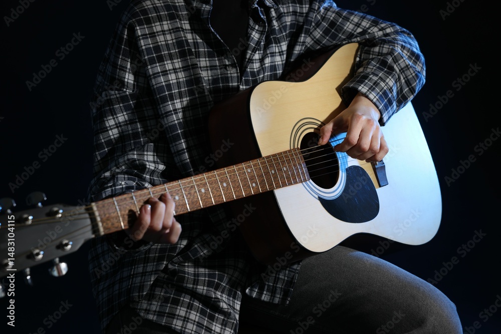 Fototapeta premium Woman playing guitar on black background, closeup