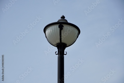 Old street lamp. Royal lamp post isolated in blue  sky background.