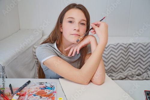 shot of a little girl painting with acrylics and imagining an idea at the table