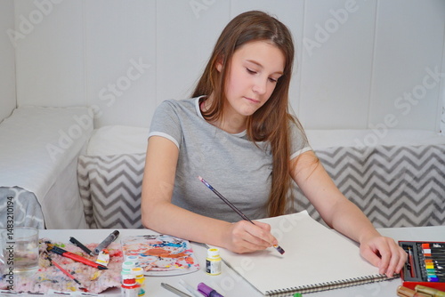 shot of a little girl painting with acrylics and imagining an idea at the table