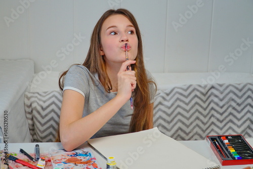 shot of a little girl painting with acrylics and imagining an idea at the table