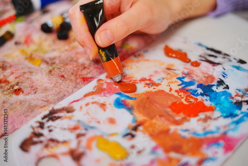 Close-up of a little girl hand squeezing paint to start painting