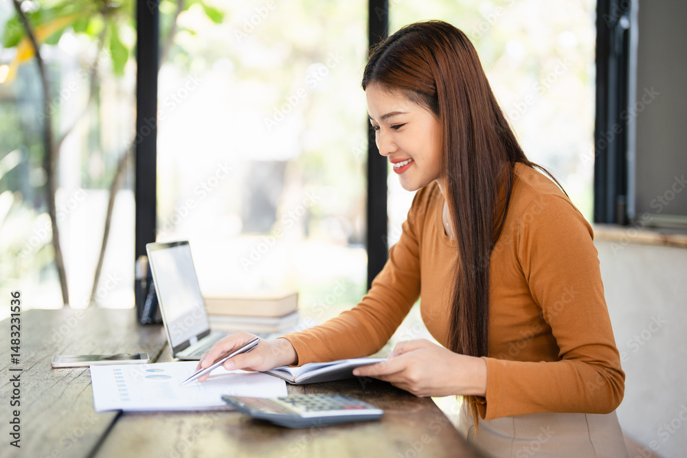 asian business woman focused on finding information on paper. Sitting at home in front of a laptop. The concept of business and online . asian business woman focused on finding information on paper. Sitting at home in front of a laptop. The concept of business and online .