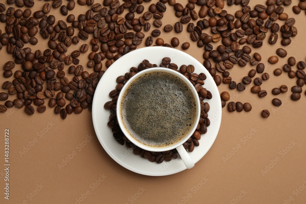 Fototapeta premium Aromatic coffee in cup and beans on beige background, flat lay