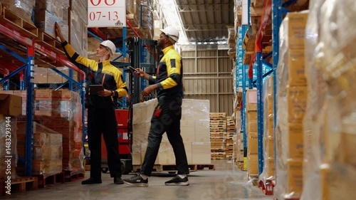Warehouse workers are inspecting goods inside the warehouse.
