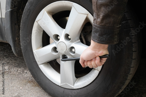Fotografie Tightening a lug nut on a car wheel with a wrench