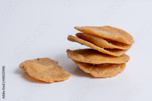 Stack og mathri, or Mathi an Indian a flaky biscuit savoury snack made with all-purpose flour, wheat  flour on white backgropund. Top view.