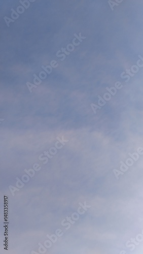 soft blue sky with light clouds, subtle cloud pattern in morning sky, peaceful blue sky with hazy texture