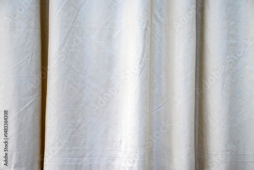 Close-up of a light fabric curtain, showcasing its folds and soft texture. Evokes privacy, comfort, and tranquility