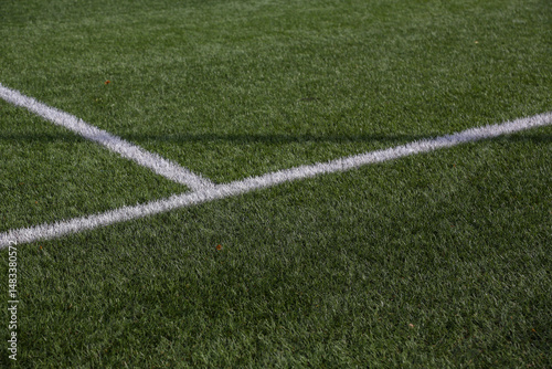 Artificial turf soccer field where we can see the goals, the corner with its flag, and the white lines.