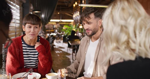 Multicultural people sitting at cafe. Multiethnic friends sitting at table. Cheerful group of people eating pizza at restaurant. Smiling friends communicating at cafe. Ethnic diversity.