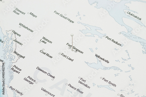 macro photo of a white pin needle into fort simpson city of Canada political map
