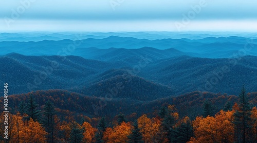 Layered mountains covered in trees stretch to the horizon under a blue sky. Ideal for backgrounds, travel articles, or conveying peace and tranquility.