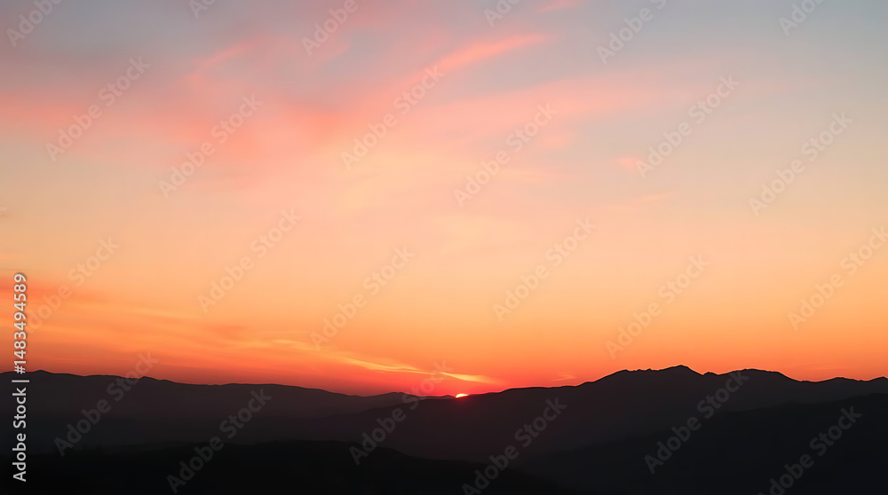 Fototapeta premium Pink and Orange Sunset Over Silhouetted Mountains