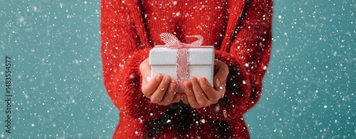 Holding a Wrapped Gift in Snowy Winter Setting During Holiday Season