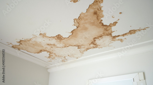 Damp damaged ceiling with peeling paint, caused by flood in need of repair