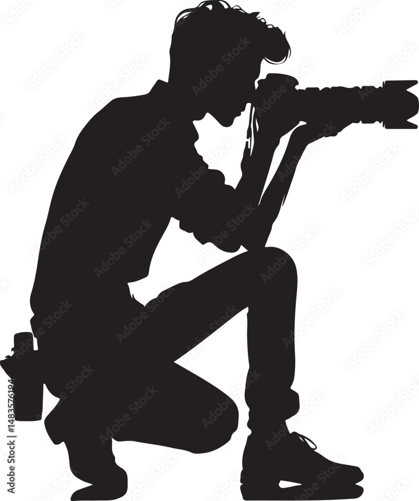 Naklejka premium A focused photographer in a crouched position, capturing a moment with a DSLR camera.