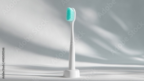White toothbrush with teal bristles, on a white base photo