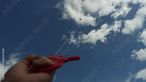 Graceful moment: a hand grips the kite string firmly as the kite climbs the vast