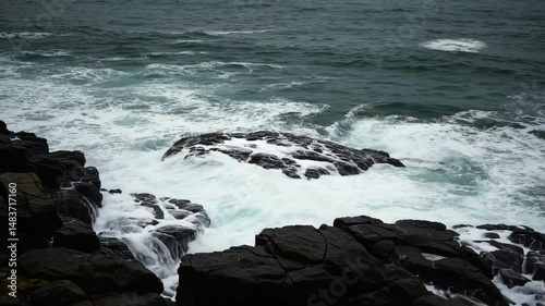 Waves crashing over rocks on a rugged coastline in stormy weather  