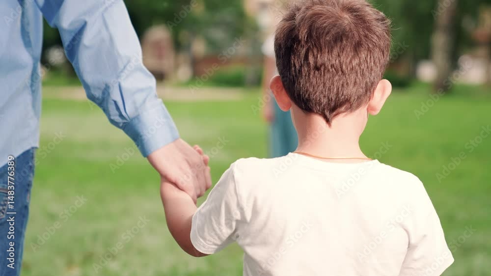 Father lets go son hand, child runs mom. Little boy lets go dads hand, runs mom, hugs her. Mom hugs son, gently stroking head. Concept happy family, motherhood. Happy family walk fresh air