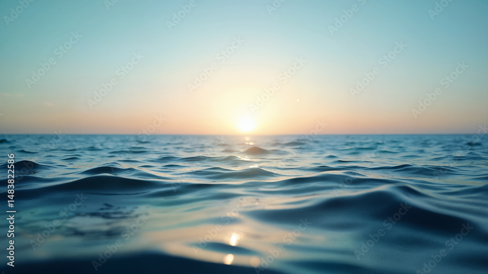 Obraz premium Ocean waves reflect the soft morning sunlight under a clear blue sky. Ideal for backgrounds, relaxation, or travel inspiration.