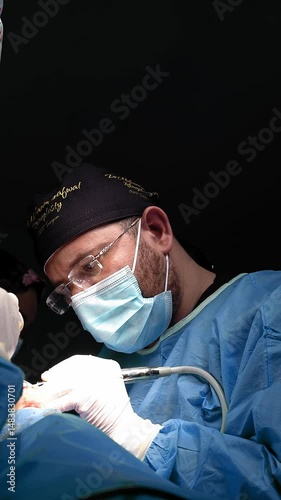 Surgeon and his assistant performing cosmetic surgery on nose in hospital operating room. Nose reshaping. Rhinoplasty. Doctor in gloves holds medical instrument during rhinoplasty.