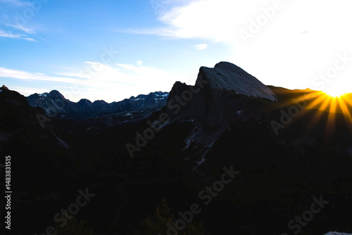 Sunrise over majestic mountain range with snow-capped peaks and serene blue sky