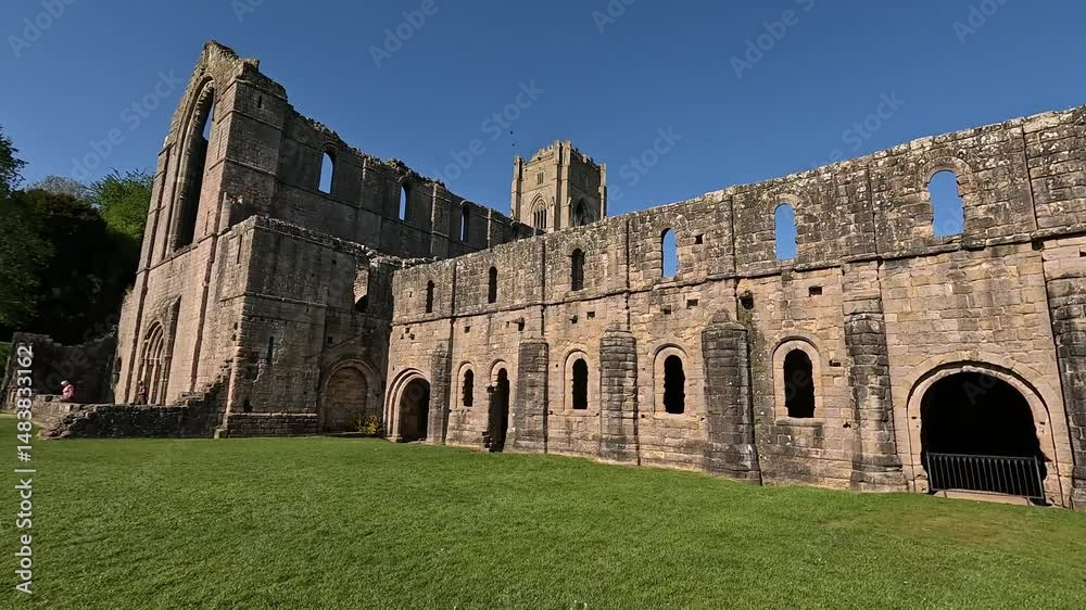 RIPON, YORKSHIRE/UK - May 11, 2025: The ruins of Fountains Abbey on a fine spring day as viewed from across the river Skell near Ripon, Fountains Abbey and Studley Royal Water Garden Yorkshire, UK. RIPON, YORKSHIRE/UK - May 11, 2025: The ruins of Fountains Abbey on a fine spring day as viewed from across the river Skell near Ripon, Fountains Abbey and Studley Royal Water Garden Yorkshire, UK.