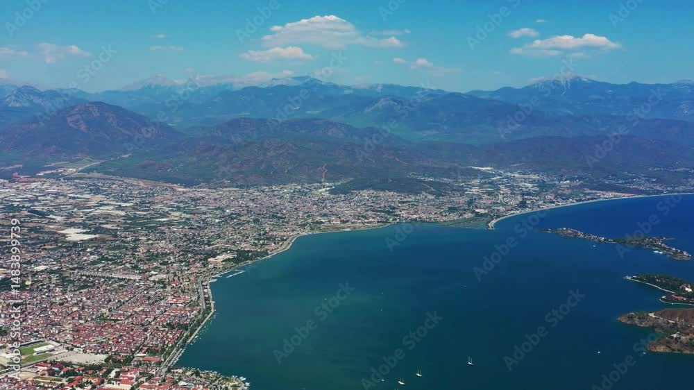 Aerial View of Coastal City with Mountain Range Background Aerial View of Coastal City with Mountain Range Background