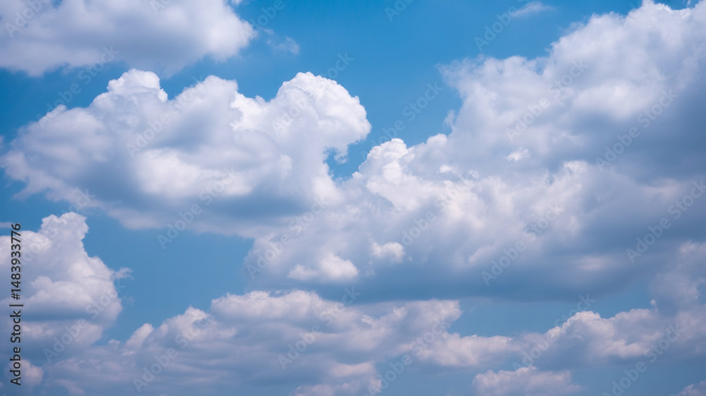 Obraz premium Beautiful fluffy white clouds floating in a vibrant blue sky during a sunny day