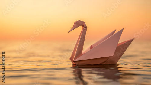 Fototapeta Naklejka Na Ścianę i Meble -  A minimalist photograph of a pale pink origami swan floating on rippling water during sunset.
