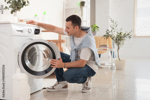 Young man using washing mac...