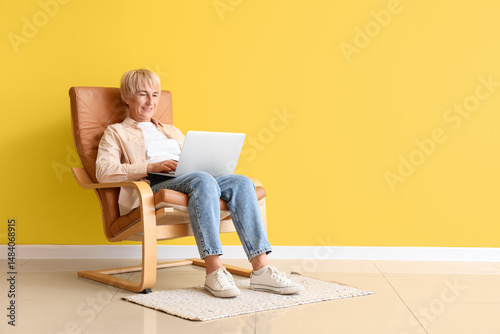 Old woman with laptop sitti...