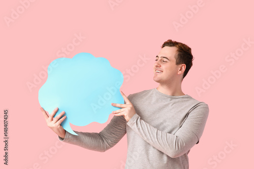 Smiling young man holding b...