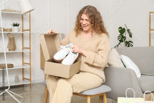 Young woman unpacking box w...