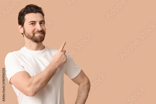 Young man pointing up on be...