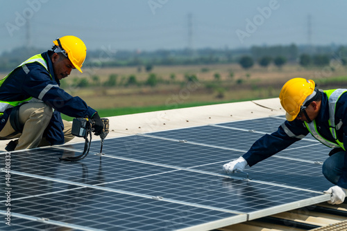 Wallpaper Mural Two engineers install solar panels on a rooftop, wearing safety gear and helmets. The scene showcases renewable energy, green technology, and sustainable solutions under a clear blue sky. Torontodigital.ca