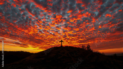 Silhouette of a cross on a hill at sunset, with vibrant clouds creating a dramatic sky, representing reflection and hope during the Good Friday celebration