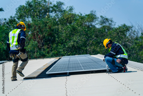 Wallpaper Mural Two engineers install solar panels on a rooftop, wearing safety gear and helmets. The scene showcases renewable energy, green technology, and sustainable solutions under a clear blue sky. Torontodigital.ca