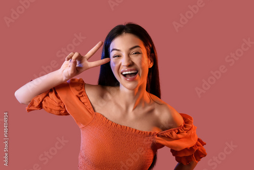 Happy young woman showing v...