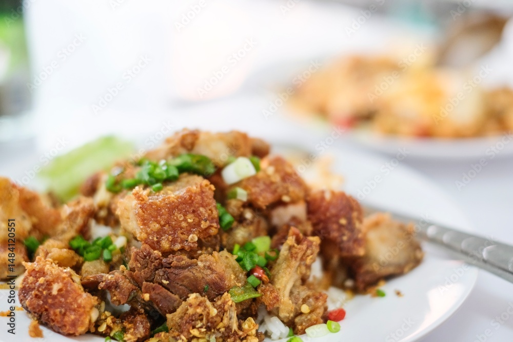 A plate of crispy pork belly stir fried with holy basil (kra pao moo grob), white rice and a fried egg at a street food stall at Soi 20 - Silom, Bangkok, Thailand A plate of crispy pork belly stir fried with holy basil (kra pao moo grob), white rice and a fried egg at a street food stall at Soi 20 - Silom, Bangkok, Thailand