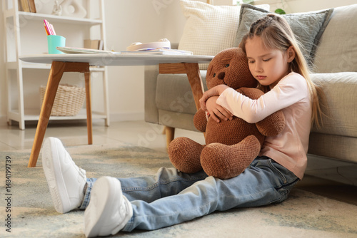Sad little girl hugging toy...