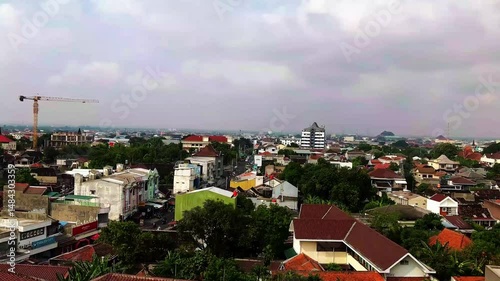 A vibrant atmosphere of Surakarta city, where tradition and modernity blend seamlessly. The city is filled with cultural landmarks, bustling markets, historical architecture, and the warmth of Javanes