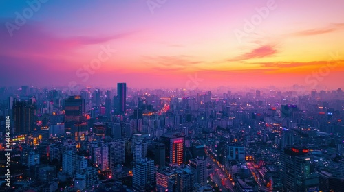 A vibrant cityscape at sunset with pink and purple hues, featuring tall buildings, streets, and a mix of urban and natural elements.